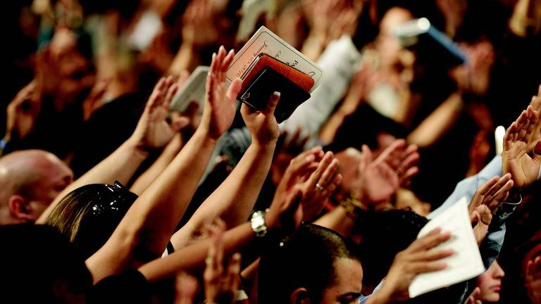 Fiéis com as mãos levantadas durante uma celebração